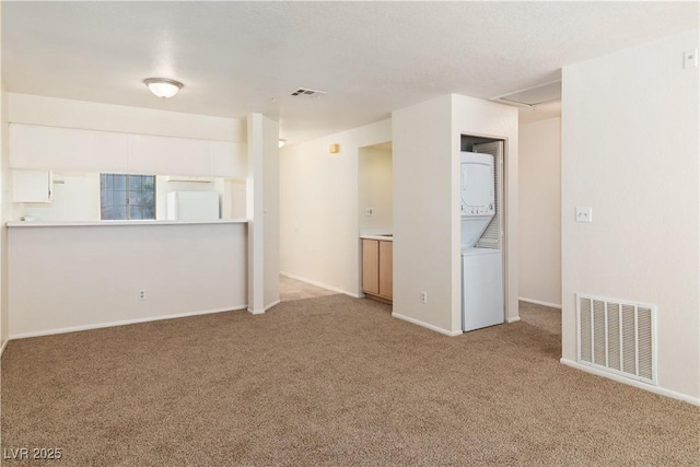 2028 Mesquite Ln Unit 302, Laughlin, NV 89029 - unfurnished room featuring stacked washer and clothes dryer and carpet flooring