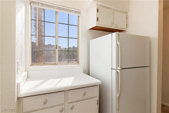 2028 Mesquite Ln Unit 302, Laughlin, NV 89029 - kitchen featuring freestanding refrigerator, white cabinetry, and light countertops