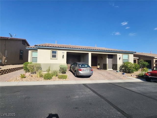2682 Chinaberry Hill St, Laughlin, NV 89029 - ranch-style house featuring decorative driveway, stucco siding, and an attached garage
