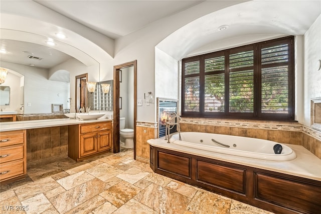 7154 Ranchito Cir, Las Vegas, NV 89120 - bathroom featuring vanity, stone tile flooring, and a tub with jets