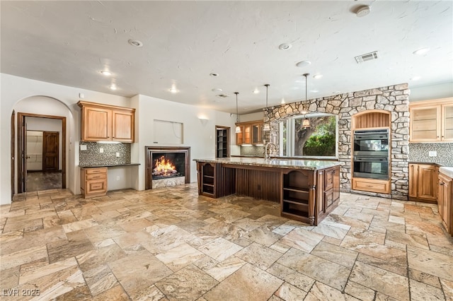 7154 Ranchito Cir, Las Vegas, NV 89120 - kitchen with decorative backsplash, open shelves, a kitchen island with sink, stone tile flooring, and recessed lighting