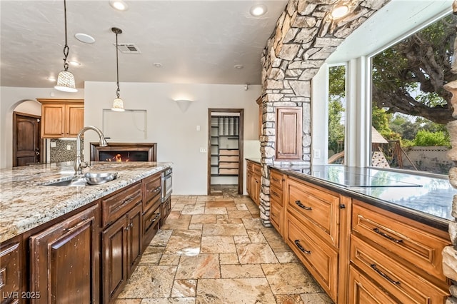 7154 Ranchito Cir, Las Vegas, NV 89120 - kitchen with stone tile floors, light stone counters, pendant lighting, and arched walkways