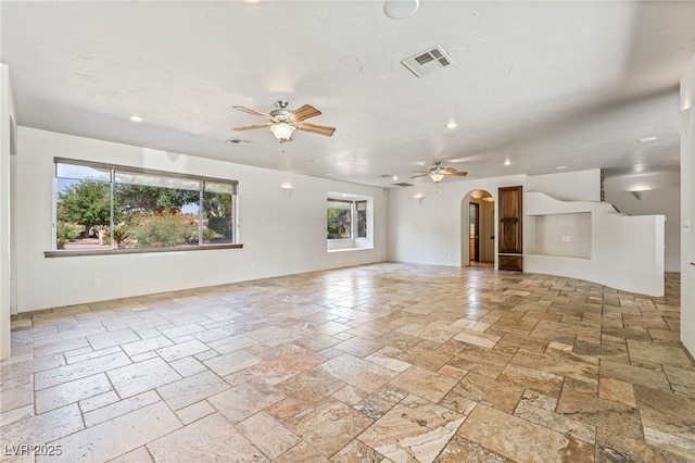 7154 Ranchito Cir, Las Vegas, NV 89120 - unfurnished living room with stone tile floors, ceiling fan, arched walkways, plenty of natural light, and recessed lighting