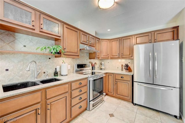 1412 5th St, Boulder City, NV 89005 - kitchen with appliances with stainless steel finishes, under cabinet range hood, decorative backsplash, light tile patterned floors, and glass insert cabinets