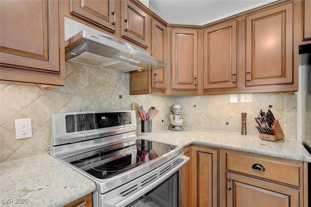 1412 5th St, Boulder City, NV 89005 - kitchen with stainless steel range with electric cooktop, under cabinet range hood, tasteful backsplash, light stone counters, and brown cabinetry