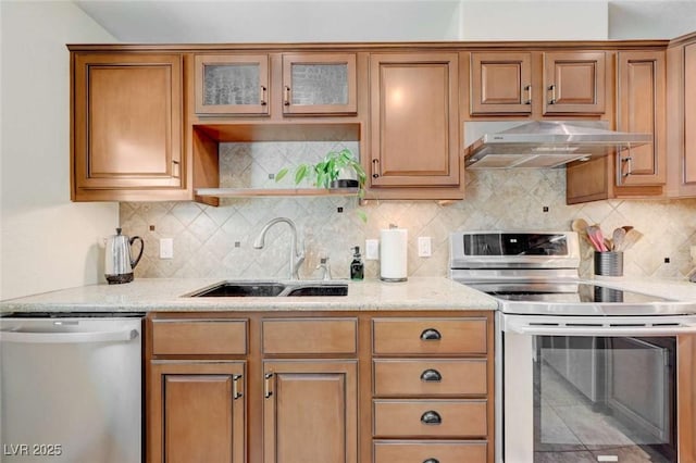 1412 5th St, Boulder City, NV 89005 - kitchen with stainless steel appliances, under cabinet range hood, light stone counters, backsplash, and brown cabinets