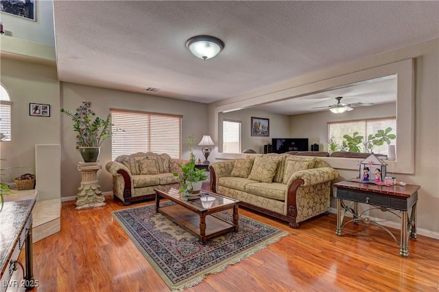 10978 Dornoch Castle St, Las Vegas, NV 89141 - living room featuring healthy amount of natural light, light wood-style flooring, a textured ceiling, and ceiling fan