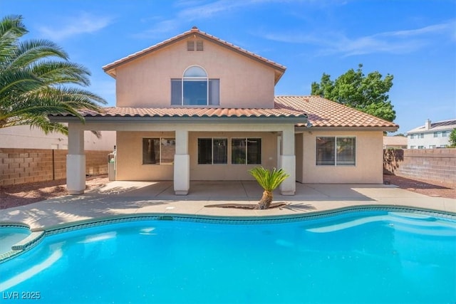 9794 Ice Box Canyon Ct, Las Vegas, NV 89117 - back of property with stucco siding, a patio area, a tiled roof, and a pool with connected hot tub