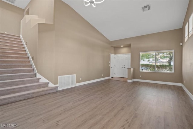 9794 Ice Box Canyon Ct, Las Vegas, NV 89117 - unfurnished living room featuring high vaulted ceiling, stairway, and wood finished floors