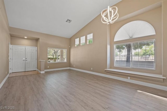 9794 Ice Box Canyon Ct, Las Vegas, NV 89117 - unfurnished living room featuring wood finished floors, a chandelier, and high vaulted ceiling