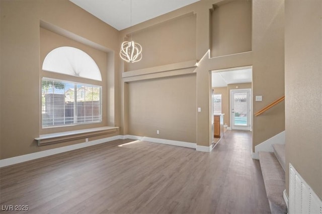 9794 Ice Box Canyon Ct, Las Vegas, NV 89117 - spare room featuring a towering ceiling, wood finished floors, a chandelier, and stairs
