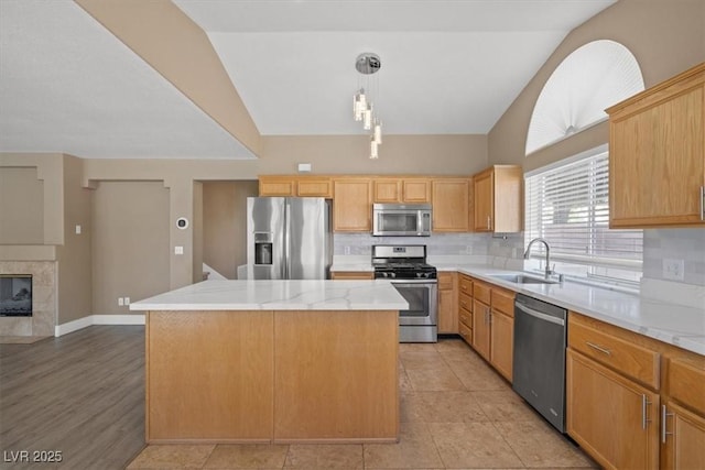 9794 Ice Box Canyon Ct, Las Vegas, NV 89117 - kitchen with appliances with stainless steel finishes, backsplash, a kitchen island, decorative light fixtures, and vaulted ceiling