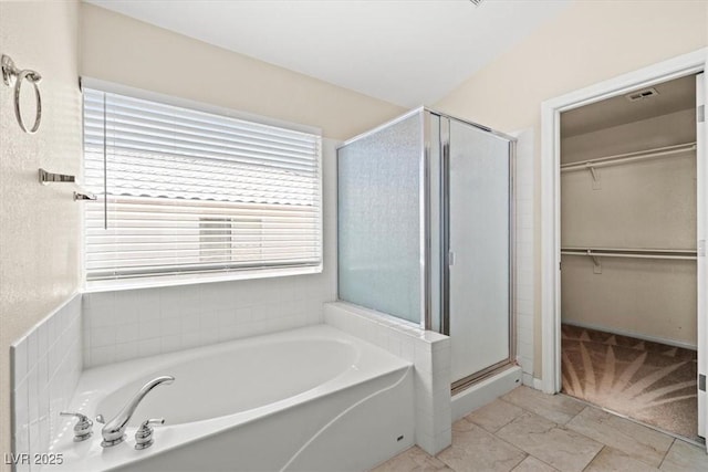 9794 Ice Box Canyon Ct, Las Vegas, NV 89117 - bathroom featuring a bath, a shower stall, and a walk in closet
