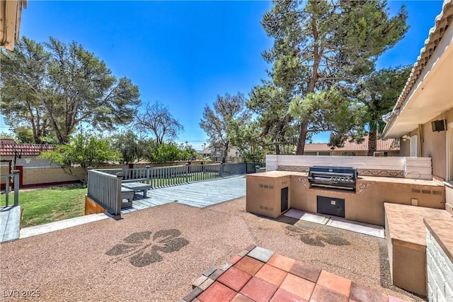 2780 Montessouri St, Las Vegas, NV 89117 - fenced backyard featuring an outdoor kitchen and a deck