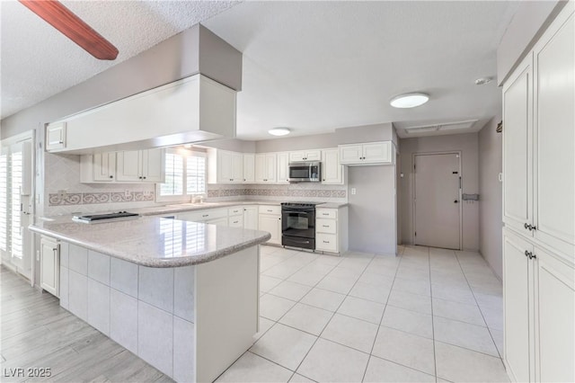 2780 Montessouri St, Las Vegas, NV 89117 - kitchen featuring black electric range oven, a peninsula, white cabinetry, stainless steel microwave, and backsplash
