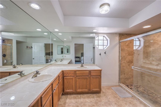1605 Siboney Dr, Las Vegas, NV 89123 - bathroom with a shower stall, double vanity, tile patterned floors, recessed lighting, and a textured ceiling
