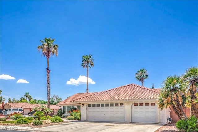 1605 Siboney Dr, Las Vegas, NV 89123 - view of front of house featuring a tiled roof, a garage, driveway, and stucco siding