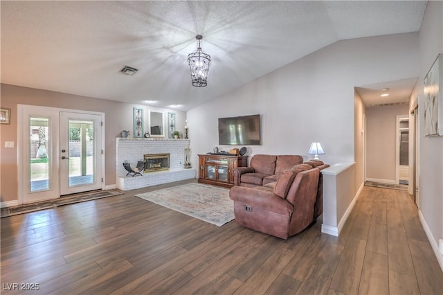 1605 Siboney Dr, Las Vegas, NV 89123 - living room with vaulted ceiling, dark wood-type flooring, a chandelier, and a fireplace