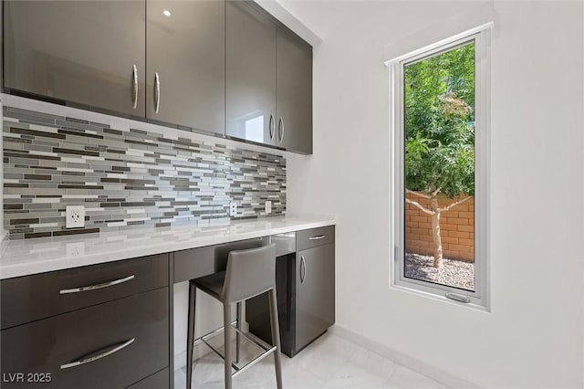 11 Hawkeye Ln, Las Vegas, NV 89135 - kitchen with modern cabinets, decorative backsplash, light countertops, and light marble finish floors