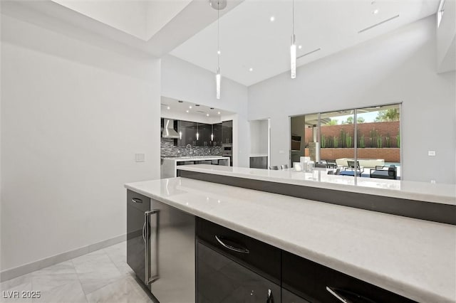 11 Hawkeye Ln, Las Vegas, NV 89135 - kitchen featuring light marble finish floors, a towering ceiling, wall chimney exhaust hood, light countertops, and backsplash