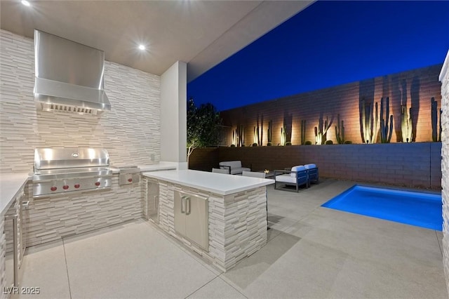 11 Hawkeye Ln, Las Vegas, NV 89135 - patio at twilight featuring exterior kitchen, a patio area, and an outdoor pool