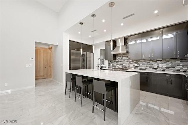 11 Hawkeye Ln, Las Vegas, NV 89135 - kitchen featuring wall chimney range hood, light marble finish flooring, modern cabinets, decorative backsplash, and recessed lighting