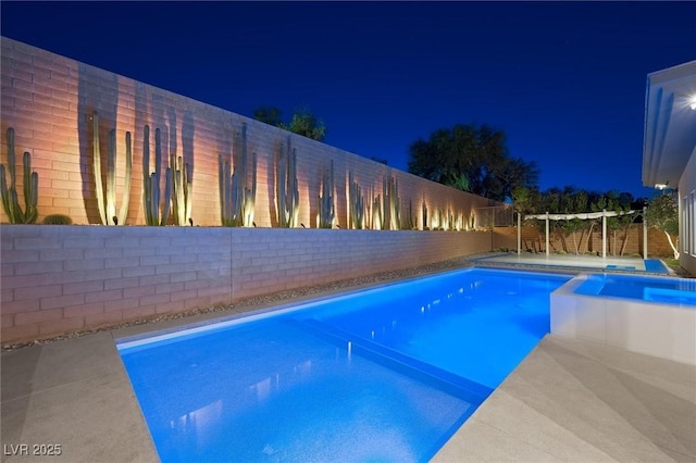 11 Hawkeye Ln, Las Vegas, NV 89135 - pool at night with a pool with connected hot tub and a fenced backyard