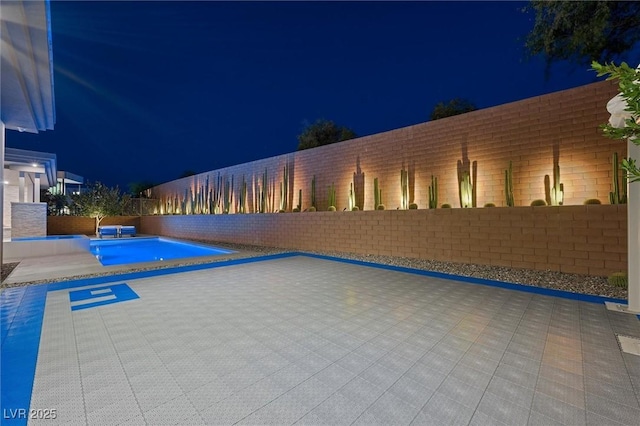 11 Hawkeye Ln, Las Vegas, NV 89135 - pool at twilight with a fenced backyard, a pool with connected hot tub, and a patio