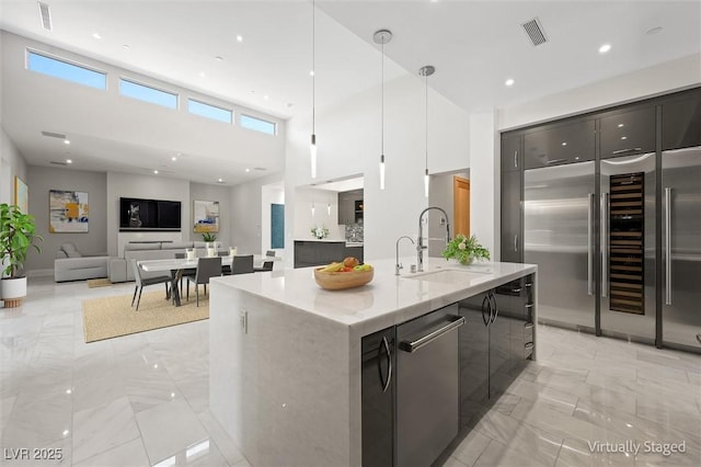 11 Hawkeye Ln, Las Vegas, NV 89135 - kitchen with stainless steel appliances, modern cabinets, light marble finish flooring, a high ceiling, and decorative light fixtures