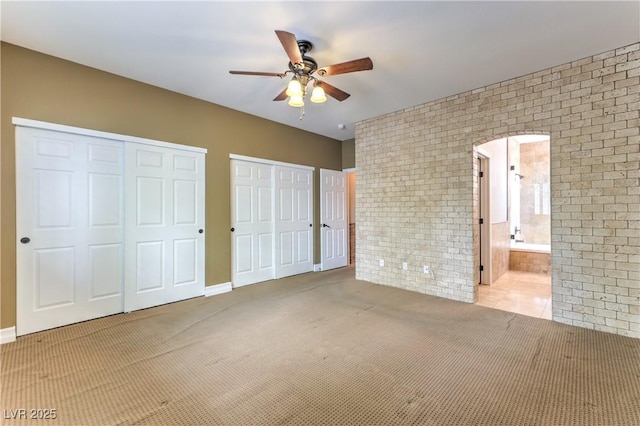 233 Ventana Heights St, Henderson, NV 89074 - unfurnished bedroom with two closets, brick wall, carpet floors, ensuite bathroom, and ceiling fan