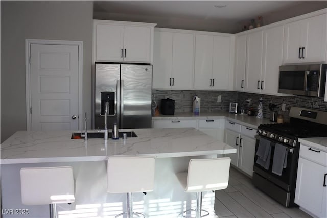 7022 Judith River St, North Las Vegas, NV 89084 - kitchen with appliances with stainless steel finishes, decorative backsplash, white cabinetry, and light stone countertops