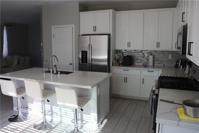 7022 Judith River St, North Las Vegas, NV 89084 - kitchen featuring stainless steel appliances, backsplash, white cabinets, and light stone counters