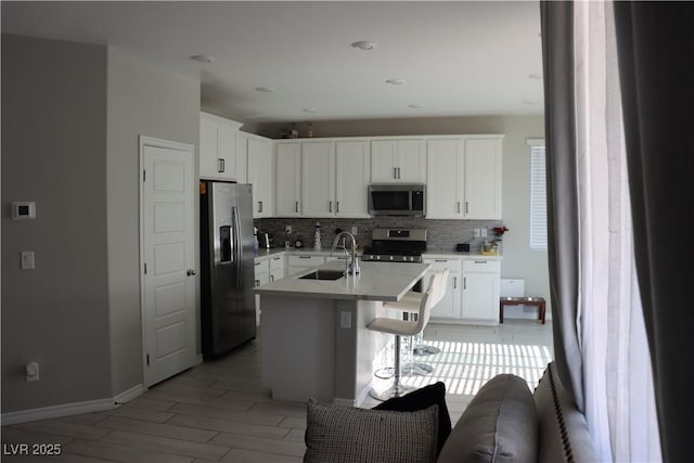 7022 Judith River St, North Las Vegas, NV 89084 - kitchen with stainless steel appliances, decorative backsplash, light countertops, a breakfast bar, and white cabinetry