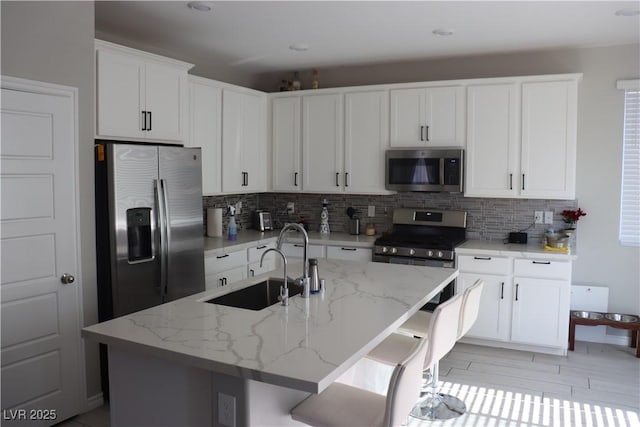 7022 Judith River St, North Las Vegas, NV 89084 - kitchen featuring appliances with stainless steel finishes, backsplash, white cabinetry, light stone countertops, and recessed lighting