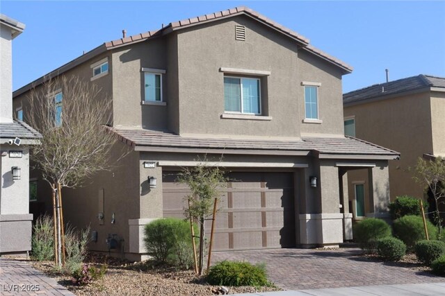 7022 Judith River St, North Las Vegas, NV 89084 - view of front of property with a garage, stucco siding, decorative driveway, and a tile roof
