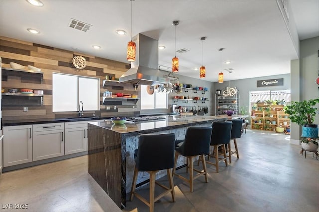 10596 Refugio St, Las Vegas, NV 89141 - kitchen with open shelves, island exhaust hood, dark countertops, finished concrete flooring, and a center island