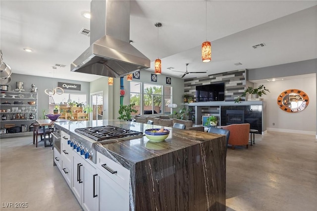 10596 Refugio St, Las Vegas, NV 89141 - kitchen with island exhaust hood, stainless steel gas cooktop, finished concrete flooring, ceiling fan, and recessed lighting