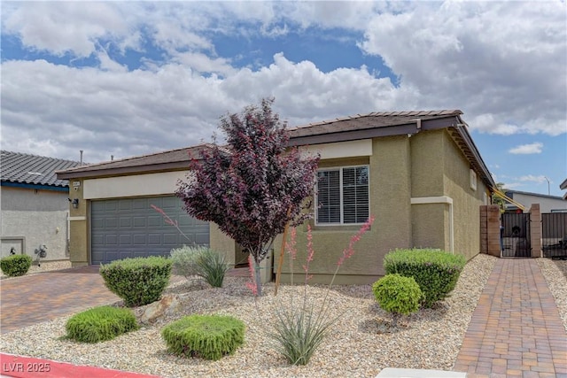 4441 Glossier Ave, North Las Vegas, NV 89084 - view of front of home featuring a gate, stucco siding, an attached garage, and decorative driveway