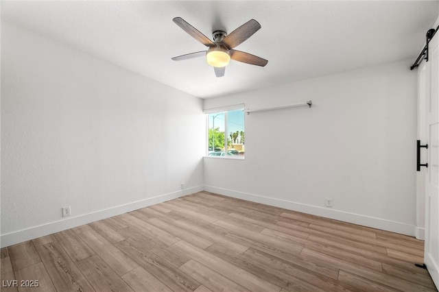 1915 Balboa Ave, Las Vegas, NV 89169 - unfurnished room with light wood-style flooring, a ceiling fan, and a barn door