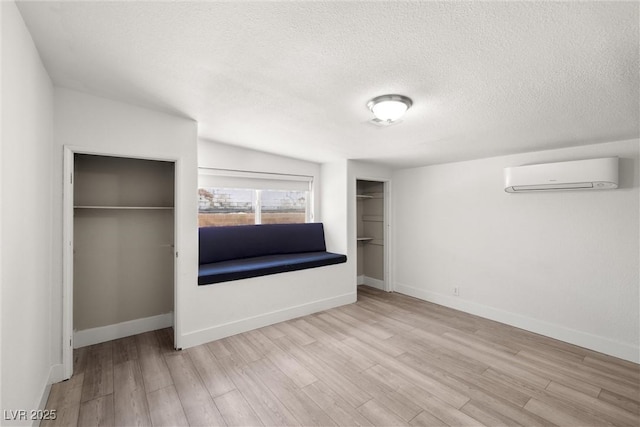 1915 Balboa Ave, Las Vegas, NV 89169 - unfurnished bedroom featuring a wall mounted air conditioner, wood finished floors, and a textured ceiling