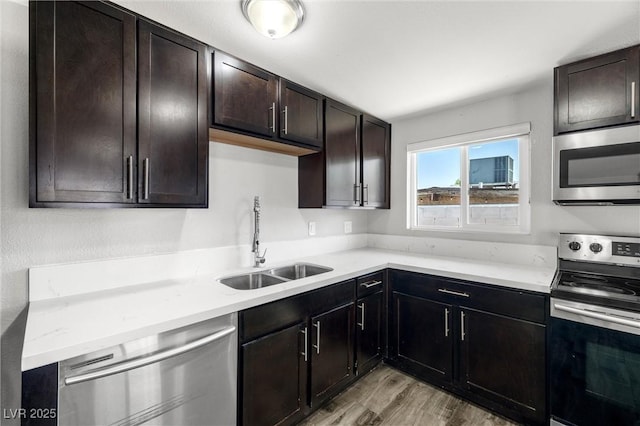 1915 Balboa Ave, Las Vegas, NV 89169 - kitchen featuring stainless steel appliances, light wood finished floors, and dark brown cabinetry