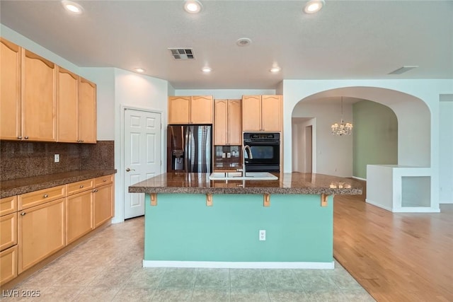 262 Pebble Canyon Dr, Las Vegas, NV 89123 - kitchen with refrigerator with ice dispenser, arched walkways, light brown cabinets, a breakfast bar, and dark stone counters