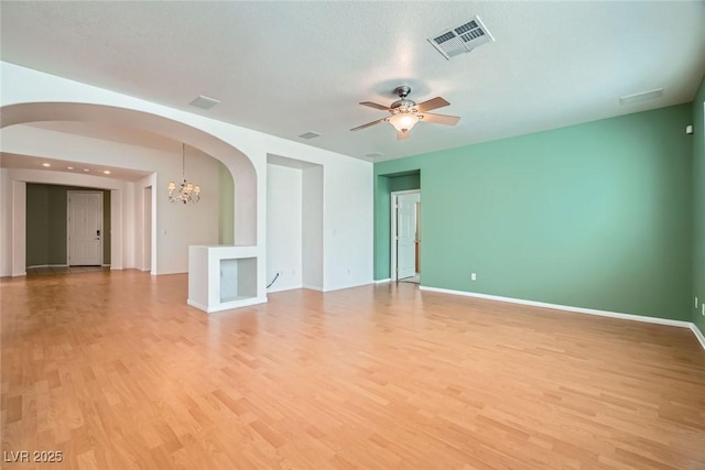 262 Pebble Canyon Dr, Las Vegas, NV 89123 - unfurnished room featuring arched walkways, light wood-style flooring, ceiling fan, and a chandelier