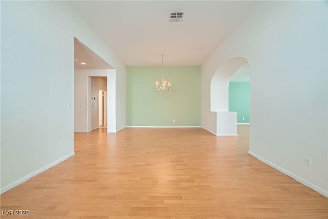 262 Pebble Canyon Dr, Las Vegas, NV 89123 - spare room with a chandelier, light wood finished floors, and arched walkways