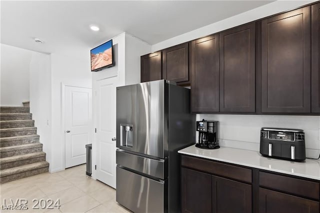 10106 Queens Pearl St, Las Vegas, NV 89141 - kitchen with stainless steel refrigerator with ice dispenser, light countertops, light tile patterned flooring, dark brown cabinets, and recessed lighting