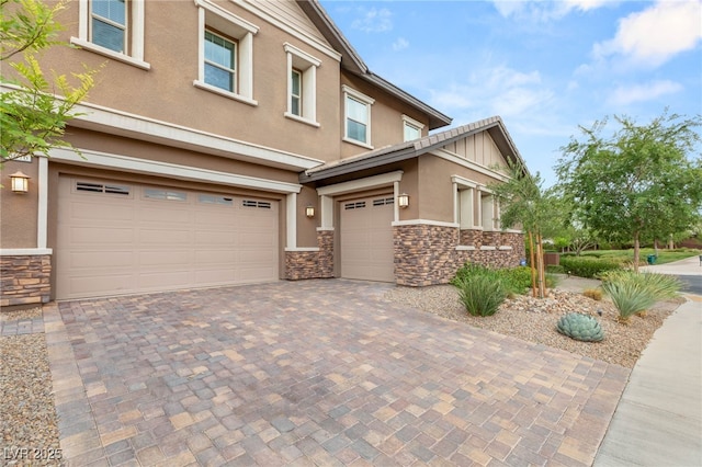5676 Corona Vista St, Las Vegas, NV 89135 - view of front of home featuring stone siding, stucco siding, an attached garage, and decorative driveway