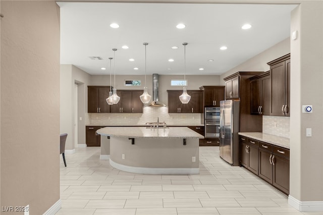 5676 Corona Vista St, Las Vegas, NV 89135 - kitchen with appliances with stainless steel finishes, wall chimney exhaust hood, backsplash, dark brown cabinetry, and recessed lighting