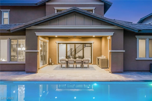 5676 Corona Vista St, Las Vegas, NV 89135 - rear view of property with stairway, stucco siding, a ceiling fan, a patio area, and an outdoor pool