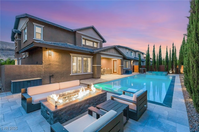 5676 Corona Vista St, Las Vegas, NV 89135 - rear view of house with stucco siding, a patio, an outdoor living space with a fire pit, and a pool with connected hot tub
