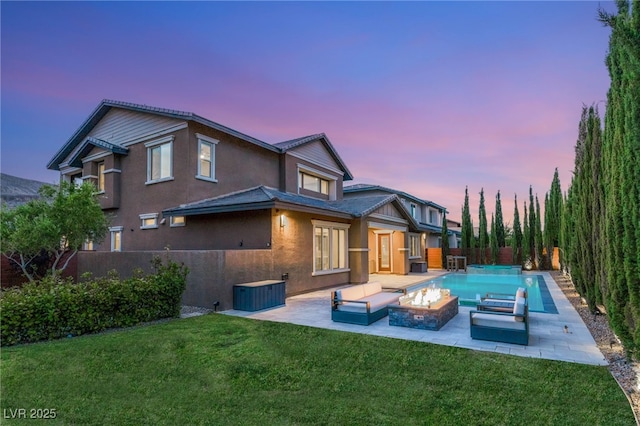 5676 Corona Vista St, Las Vegas, NV 89135 - back of house at dusk featuring a patio, stucco siding, a fenced backyard, and a fire pit